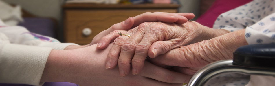 nurse holding hands of olders women